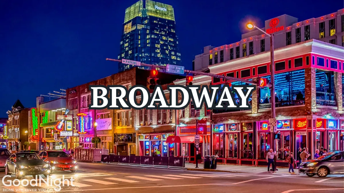 A vibrant nighttime street scene in Nashville, showcasing colorful neon signs, bustling sidewalks, high-rise buildings, and crowds of people enjoying the city's nightlife. The energy and movement capture the spirit of Nashville’s entertainment district.
